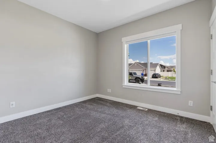 Carpeted empty room with baseboards