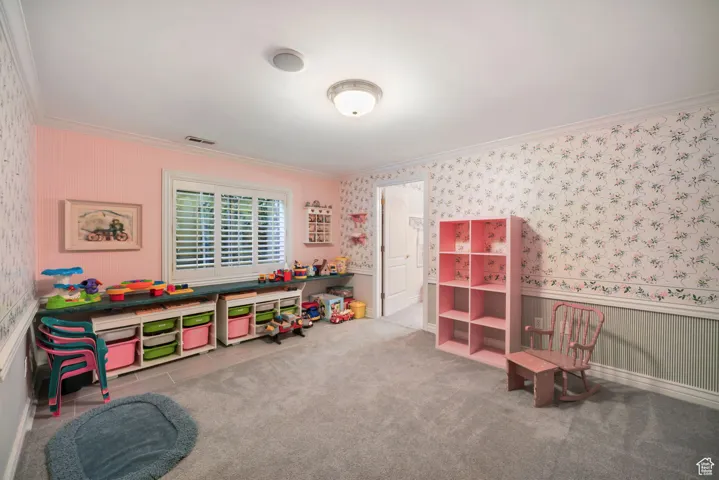 Recreation room with crown molding and wallpapered walls