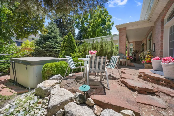 View of patio featuring outdoor dining space and a hot tub