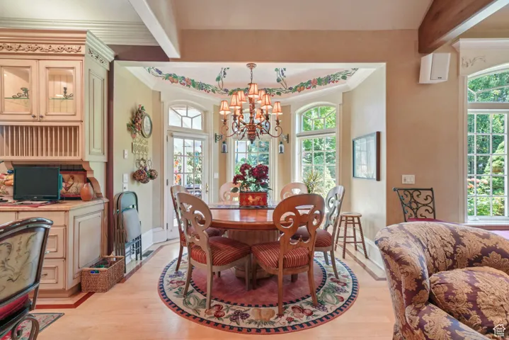 Dining space featuring a chandelier, light wood-type flooring, and ornamental molding