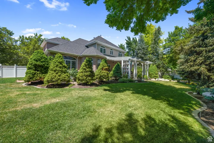 View of front of property with a pergola, brick siding, and roof with shingles