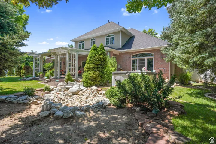 Rear view of house with a pergola, brick siding, roof with shingles, a yard, and a patio area