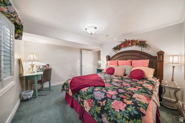 Bedroom featuring carpet flooring, crown molding, and multiple windows