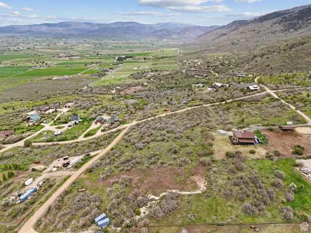 Aerial overview of property's location featuring a mountain backdrop and rural landscape