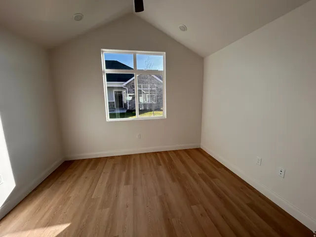 Additional living space featuring light wood finished floors and vaulted ceiling
