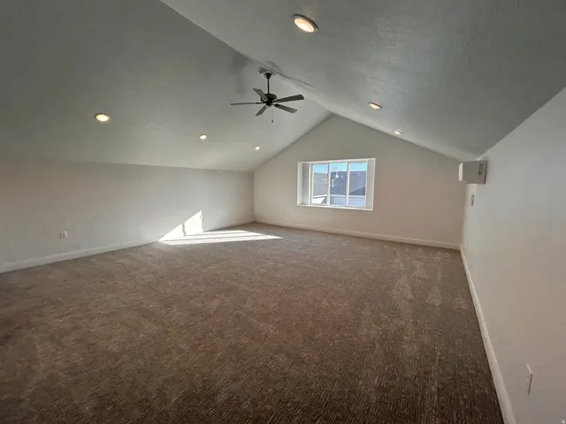 Bonus room with dark carpet, vaulted ceiling, a ceiling fan, and recessed lighting
