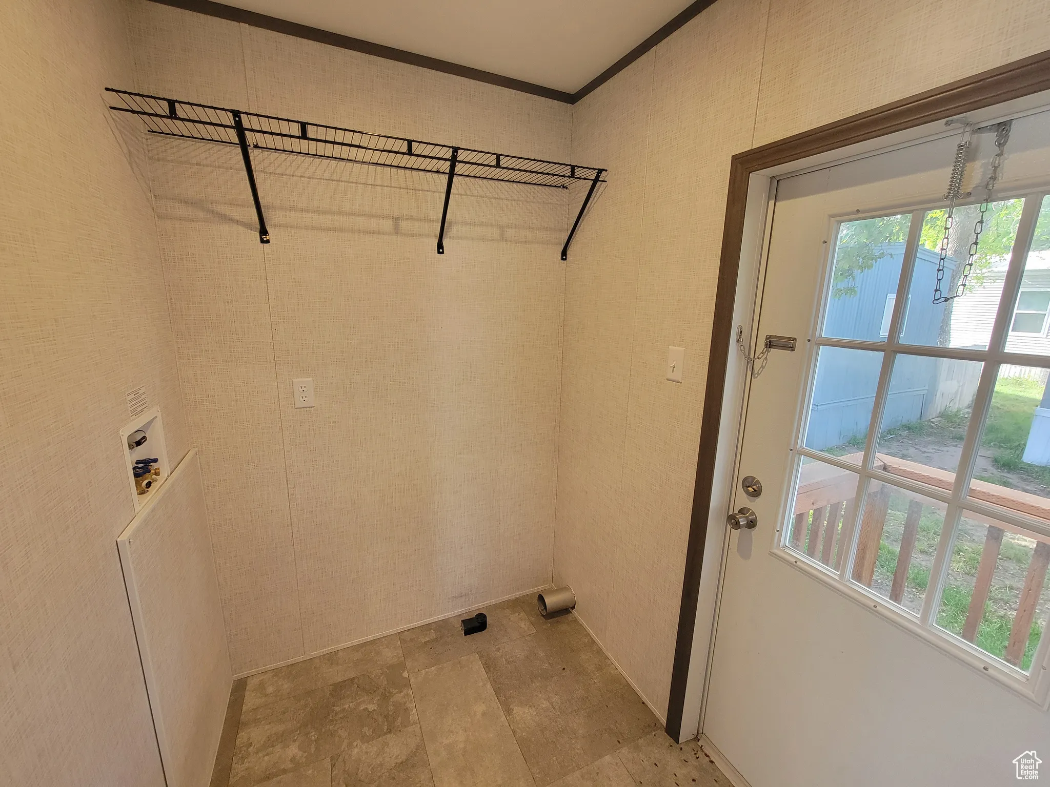 Laundry area featuring plenty of natural light, washer hookup, stone finish flooring, and ornamental molding