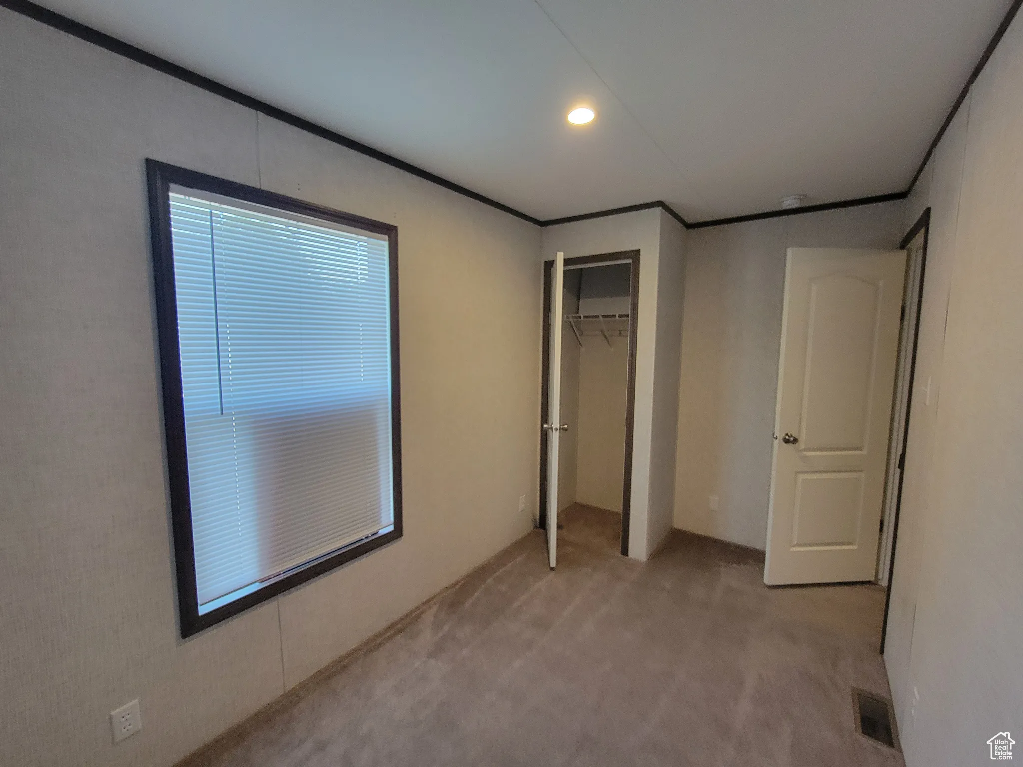 Unfurnished bedroom with light colored carpet, recessed lighting, a closet, and ornamental molding