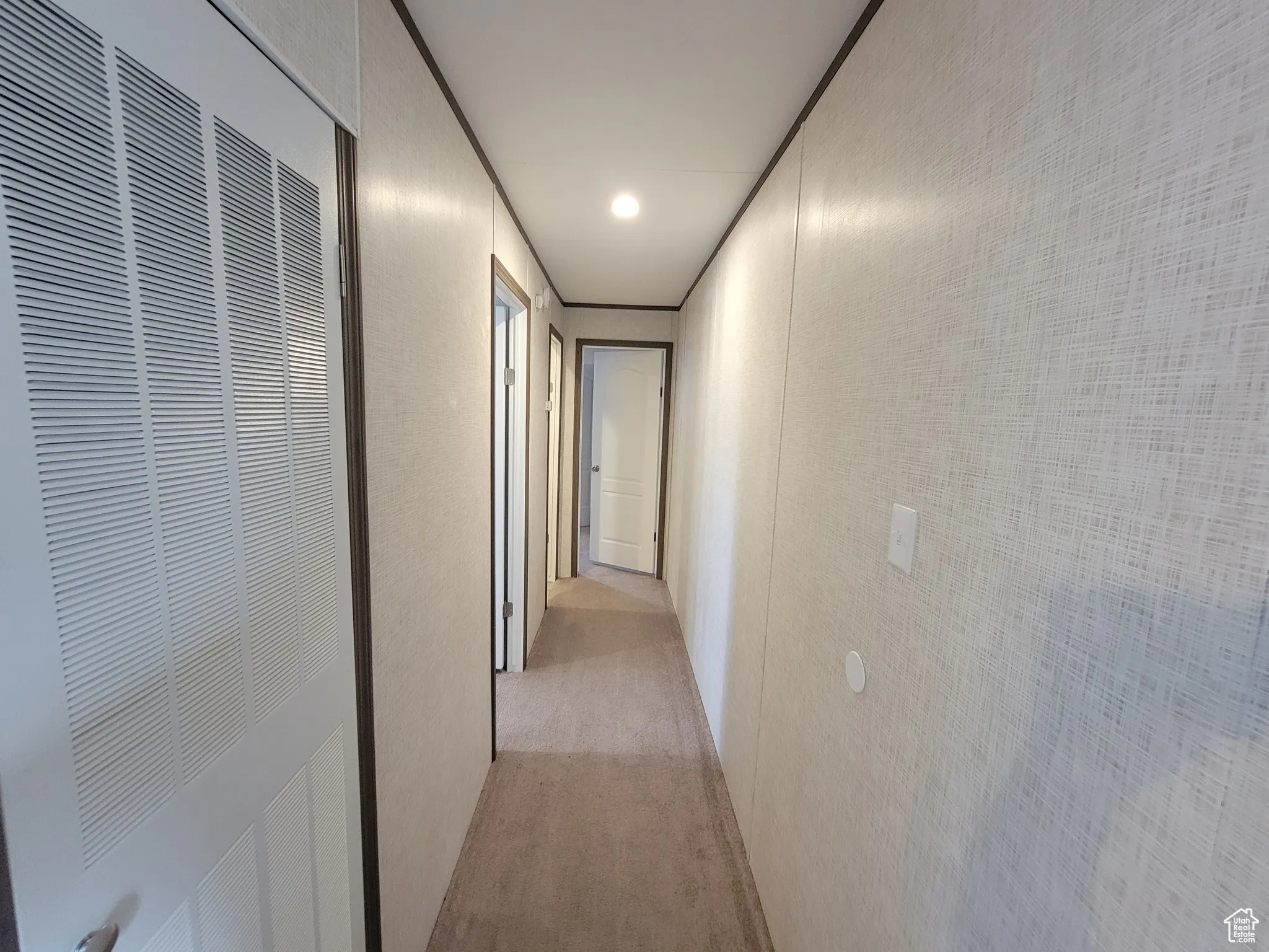 Corridor with a heating unit and light colored carpet