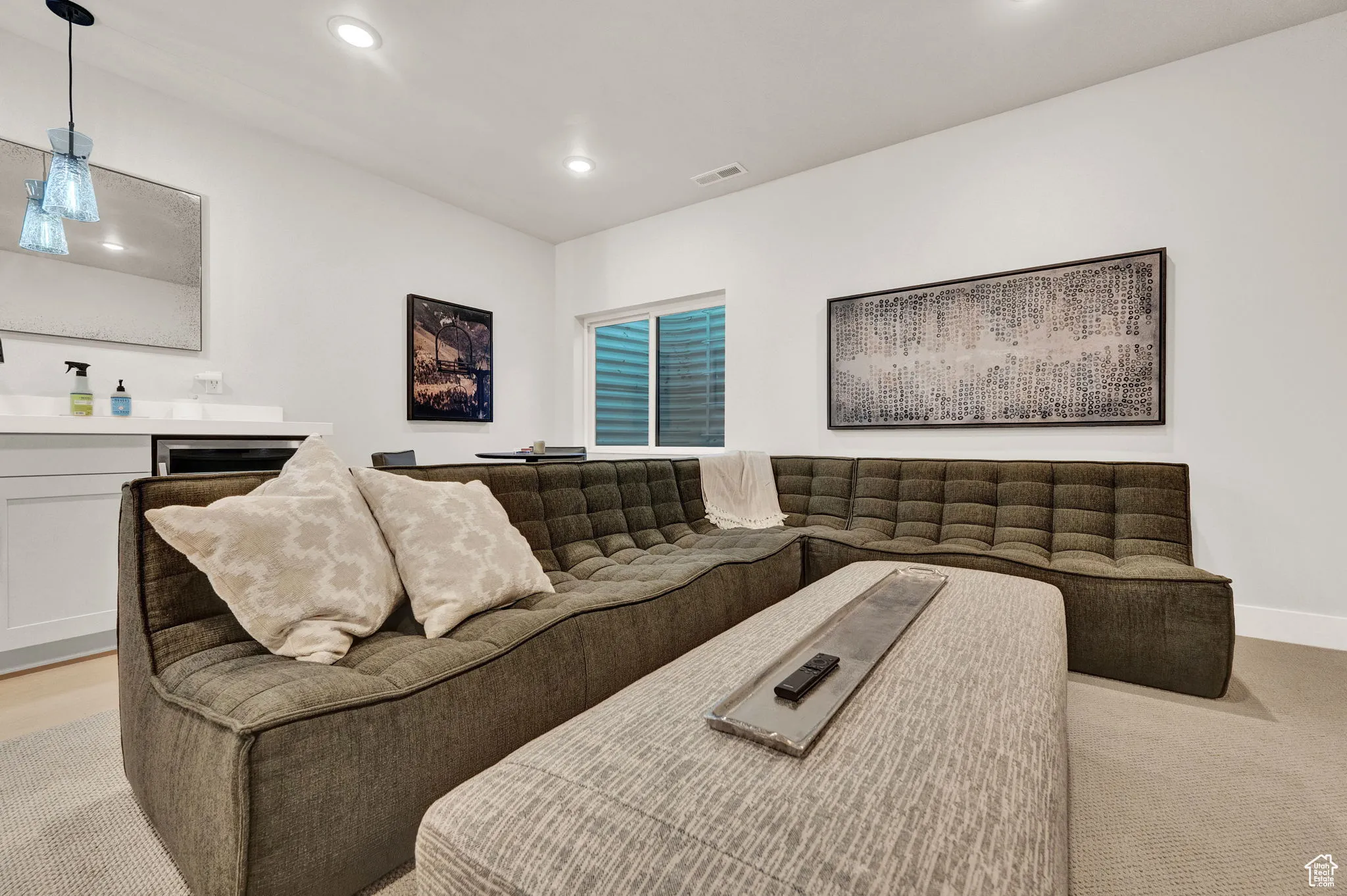 Living room with recessed lighting, bar area, light carpet, and baseboards