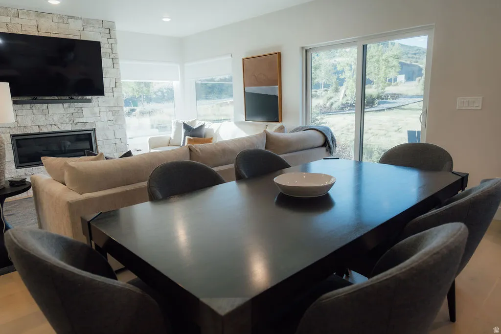 Open-concept living area featuring a stone-clad fireplace, built-in television mount, and expansive sliding glass doors