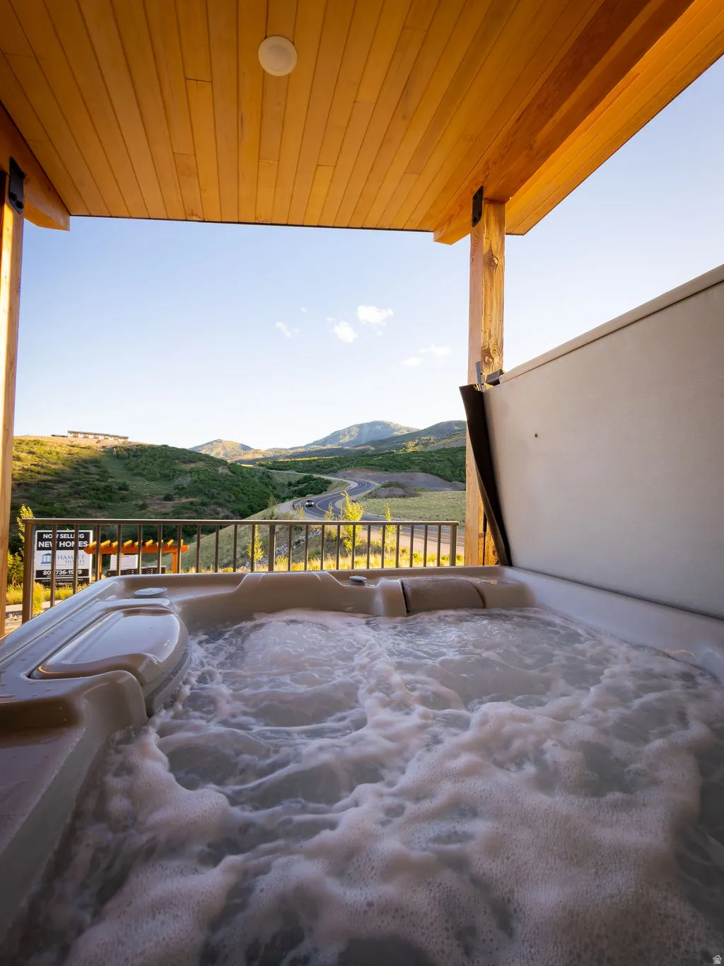 Covered outdoor spa featuring a bubbling water feature and an open cover