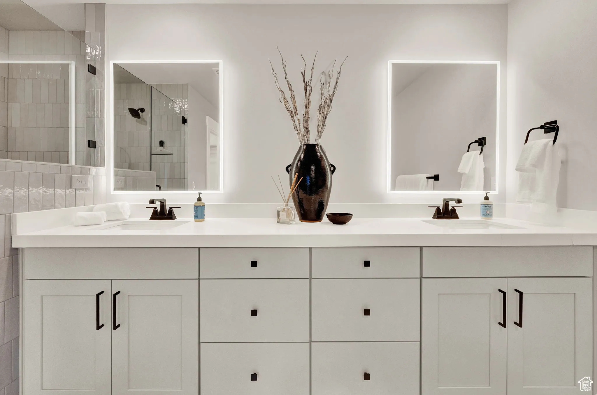 Bathroom featuring double vanity and a shower stall