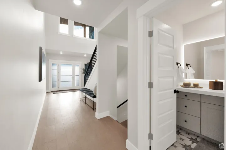Hall featuring baseboards, recessed lighting, and stairs