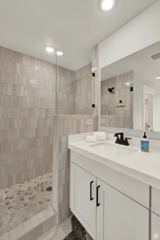 Bathroom with walk in shower, vanity, and recessed lighting