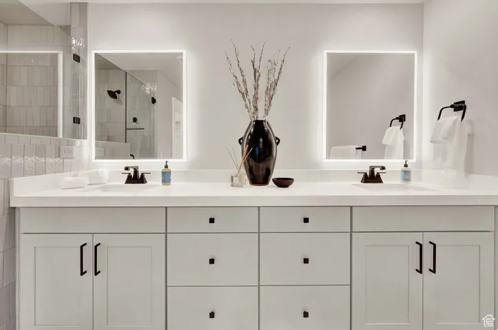 Bathroom featuring double vanity and a shower stall