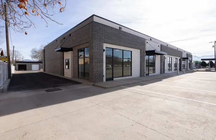 Rear view of property featuring brick siding and an outdoor structure