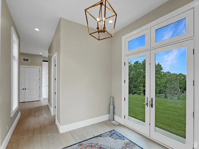 Doorway to outside with light wood-style floors, a chandelier, recessed lighting, baseboards, and french doors