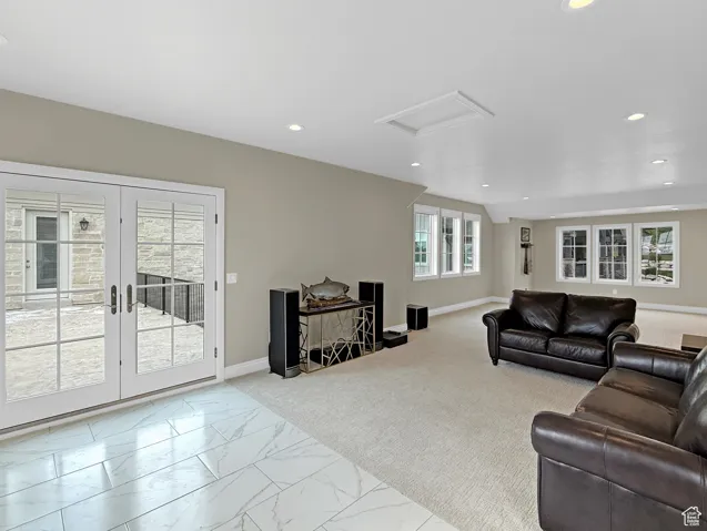 Above garage living room featuring carpet floors, vaulted ceiling, baseboards, and recessed lighting