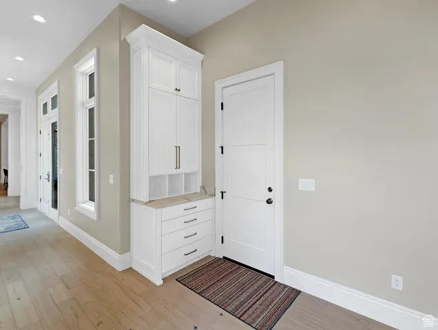 Garage entrance featuring light wood-style floors, baseboards, and recessed lighting
