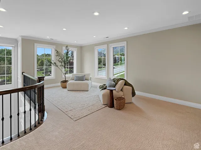 Sitting room with an upstairs landing, carpet floors, ornamental molding, baseboards, and recessed lighting