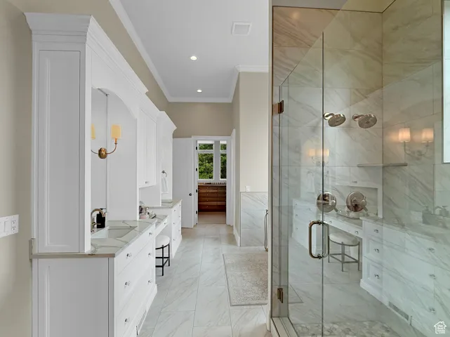 Bathroom featuring vanity, ornamental molding, a stall shower, marble finish floors, and recessed lighting