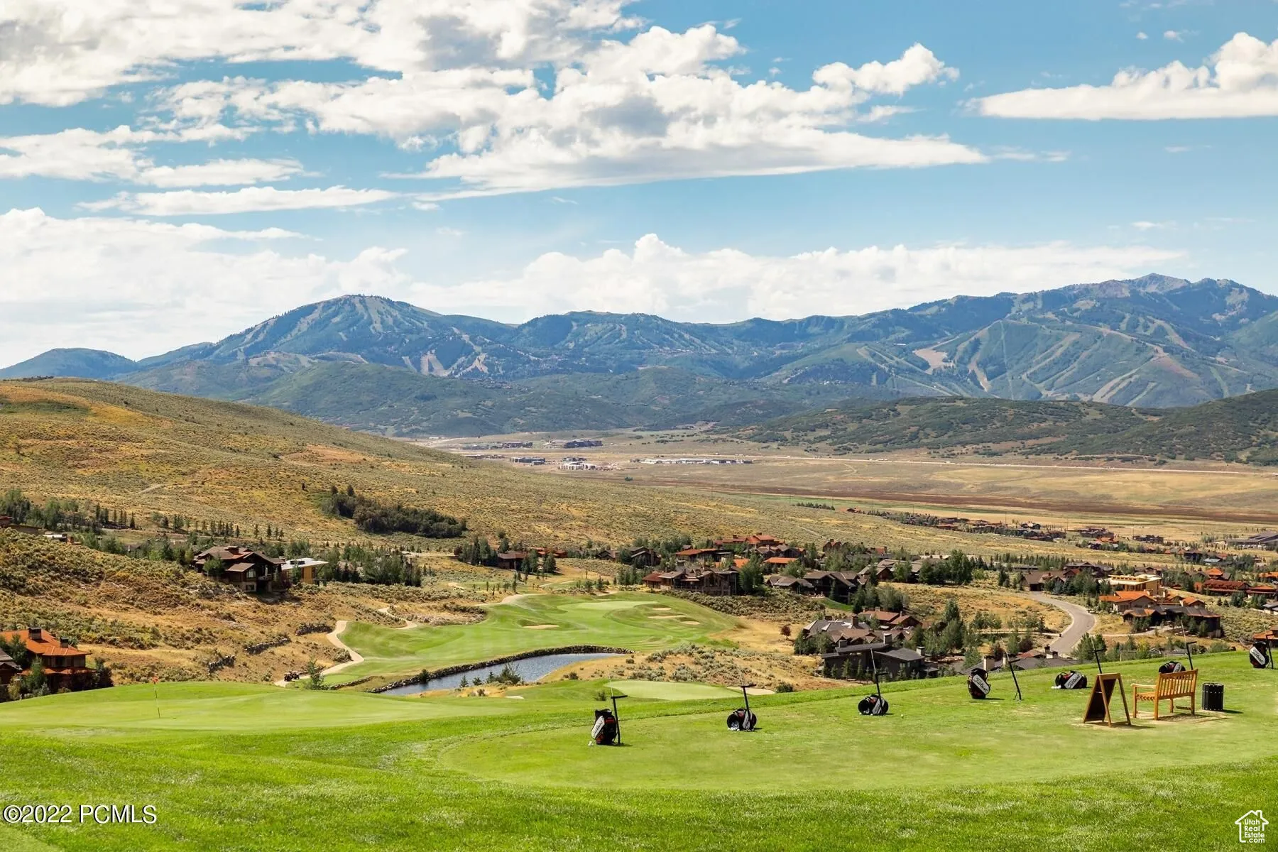 View of mountain background with a golf course and a nearby body of water