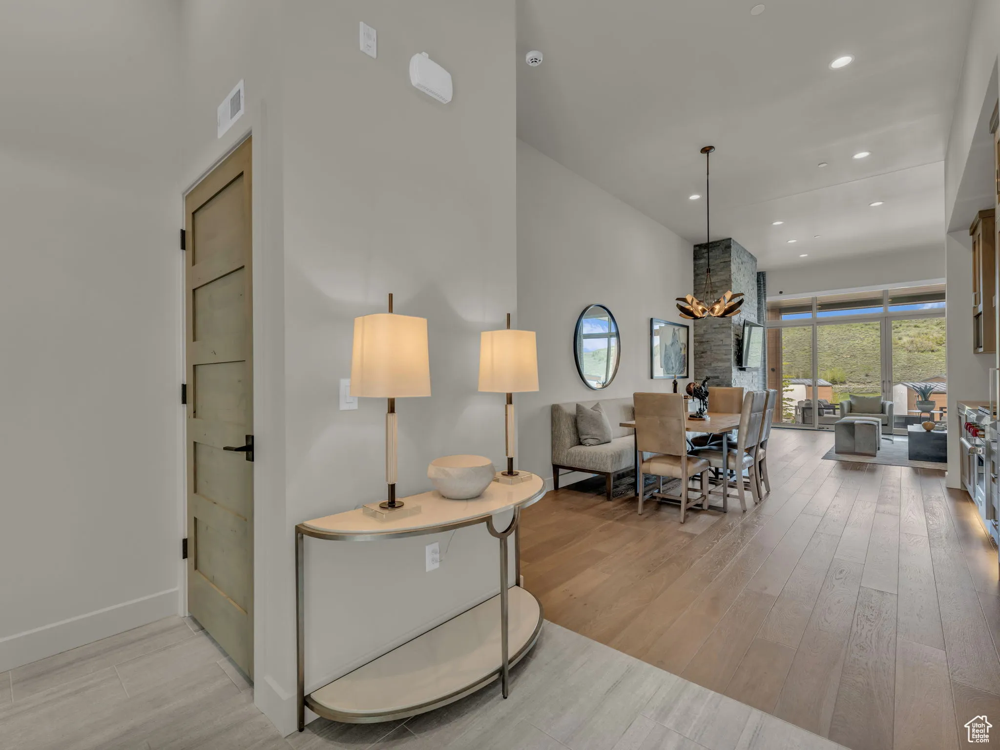 Living room with wood finished floors, a towering ceiling, recessed lighting, and a chandelier