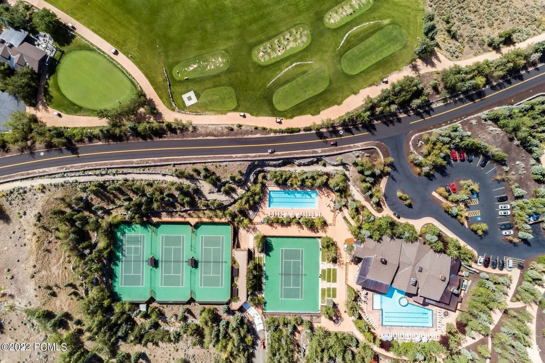 Aerial view of property and surrounding area with a golf club