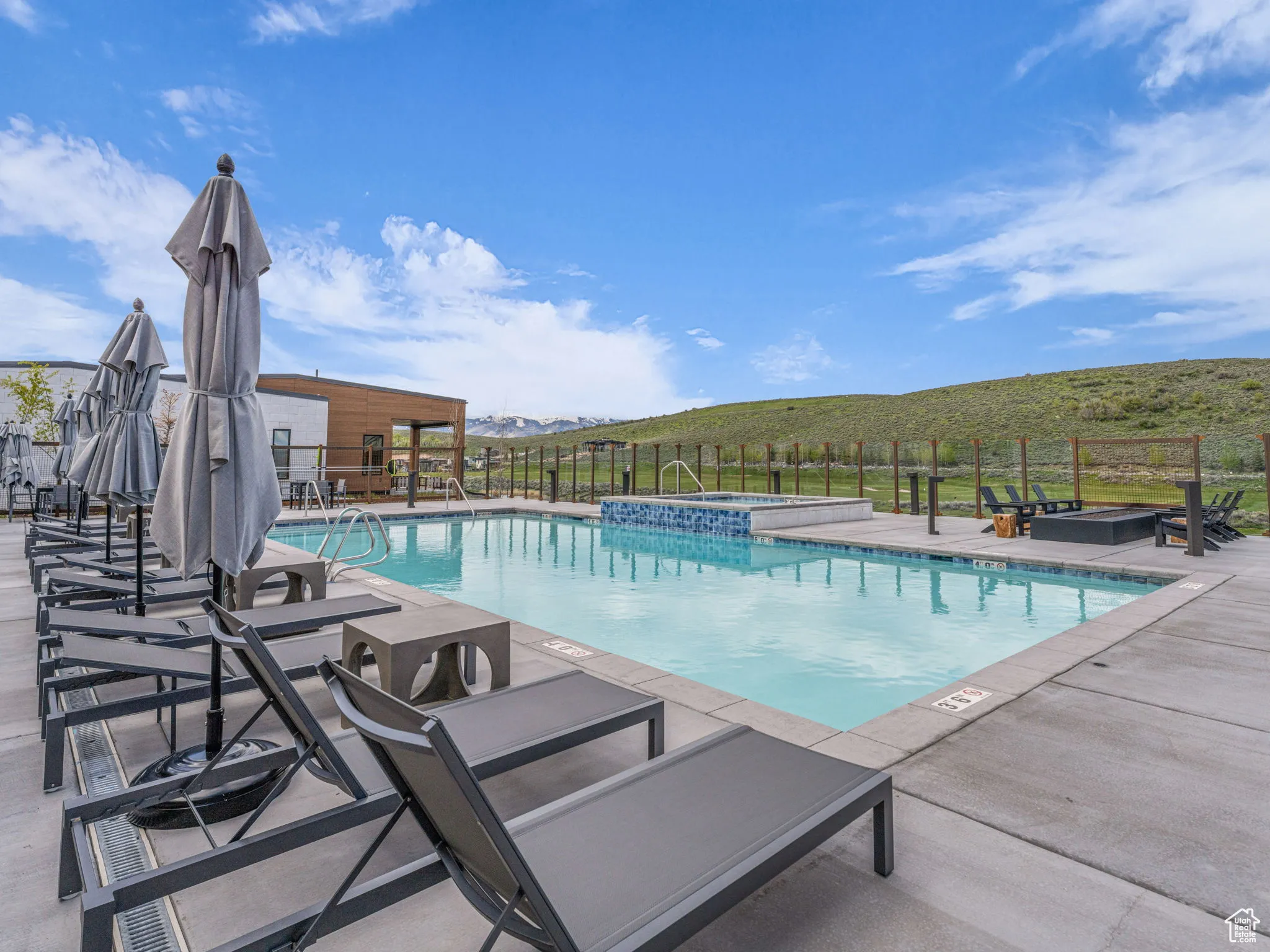 View of swimming pool featuring a pool with connected hot tub and a patio area
