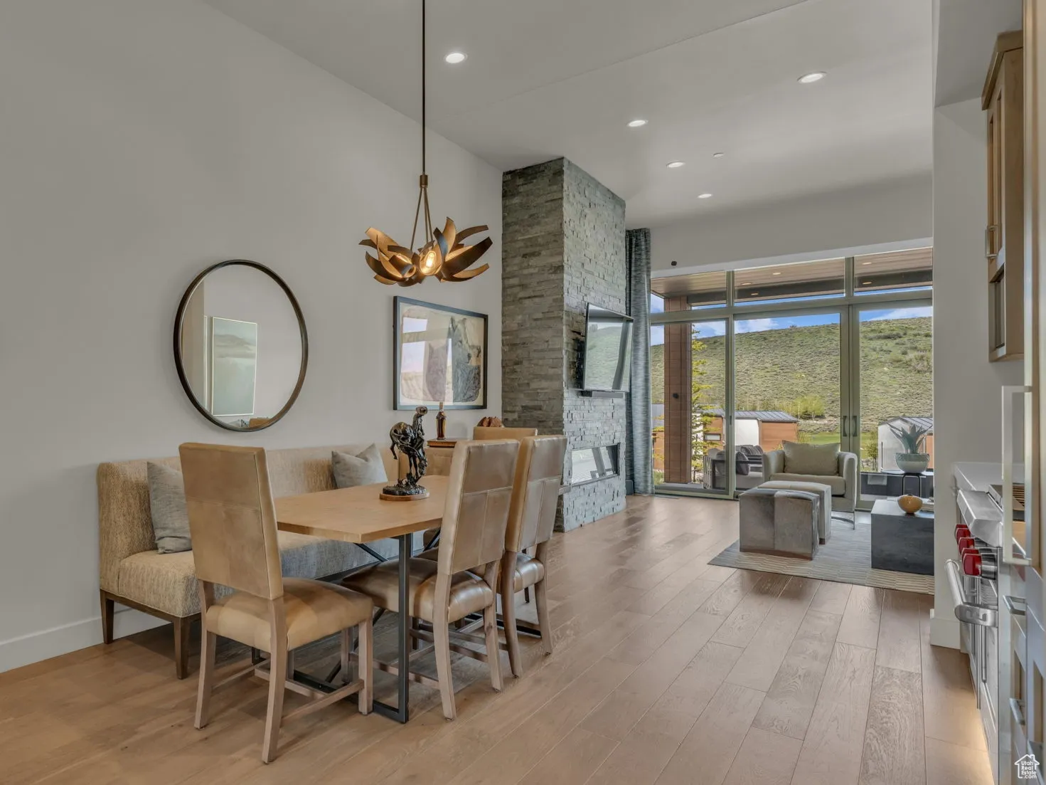 Dining room with light wood-style floors, a towering ceiling, a chandelier, recessed lighting