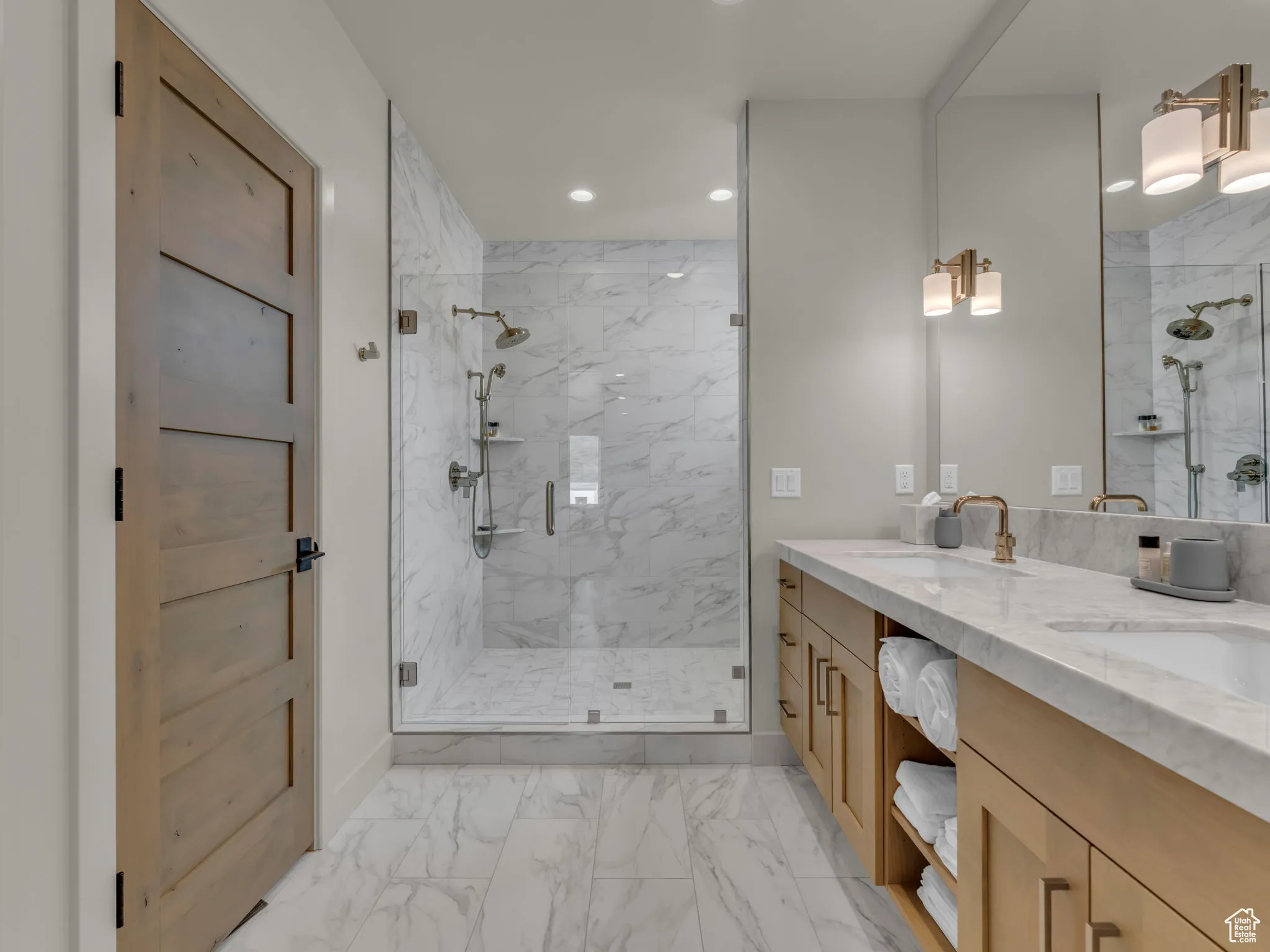 Bathroom with marble look tiles, a marble finish shower, recessed lighting, double vanity, and baseboards