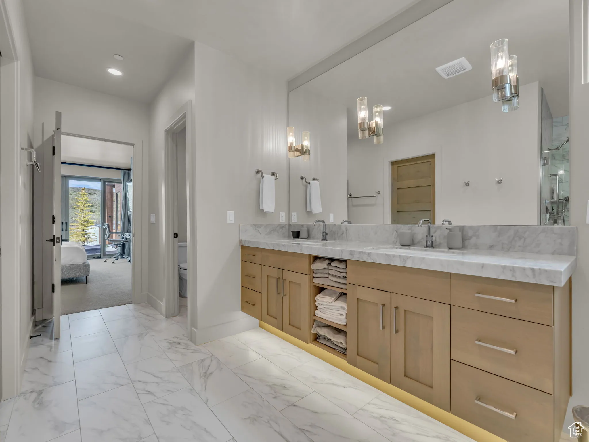 Ensuite bathroom featuring double vanity, toilet, baseboards, a chandelier, and recessed lighting