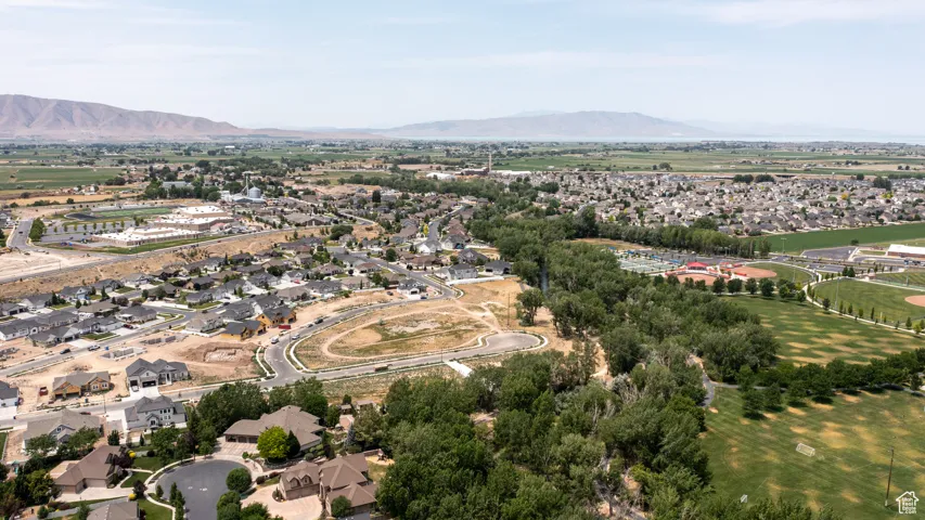Aerial overview of property's location with a mountain backdrop and nearby suburban area