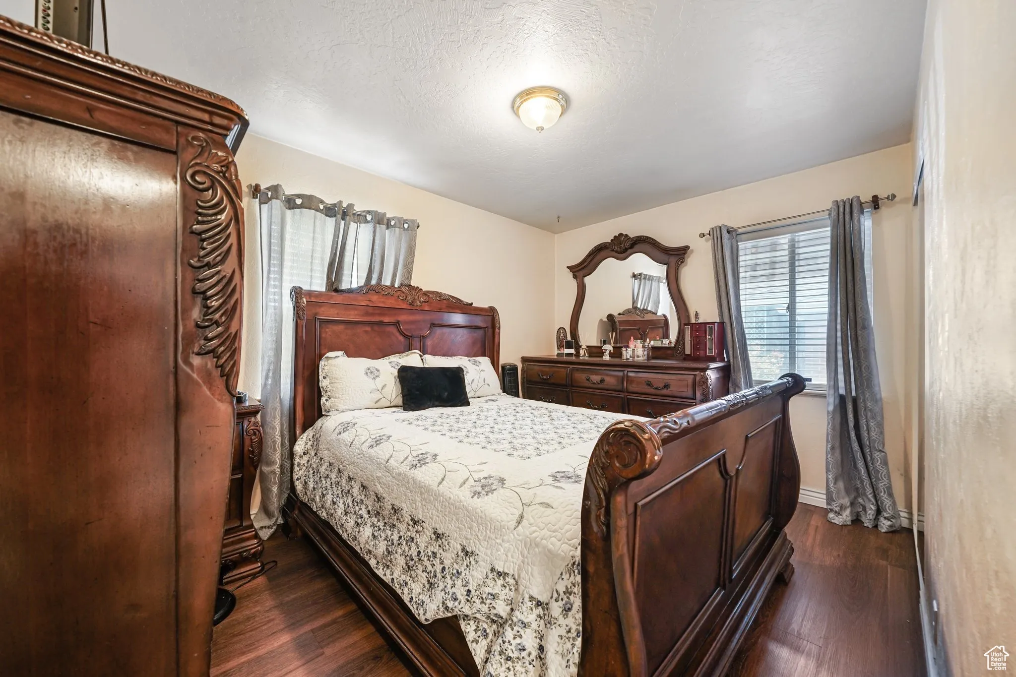Bedroom featuring dark wood finished floors, baseboards, and a textured ceiling