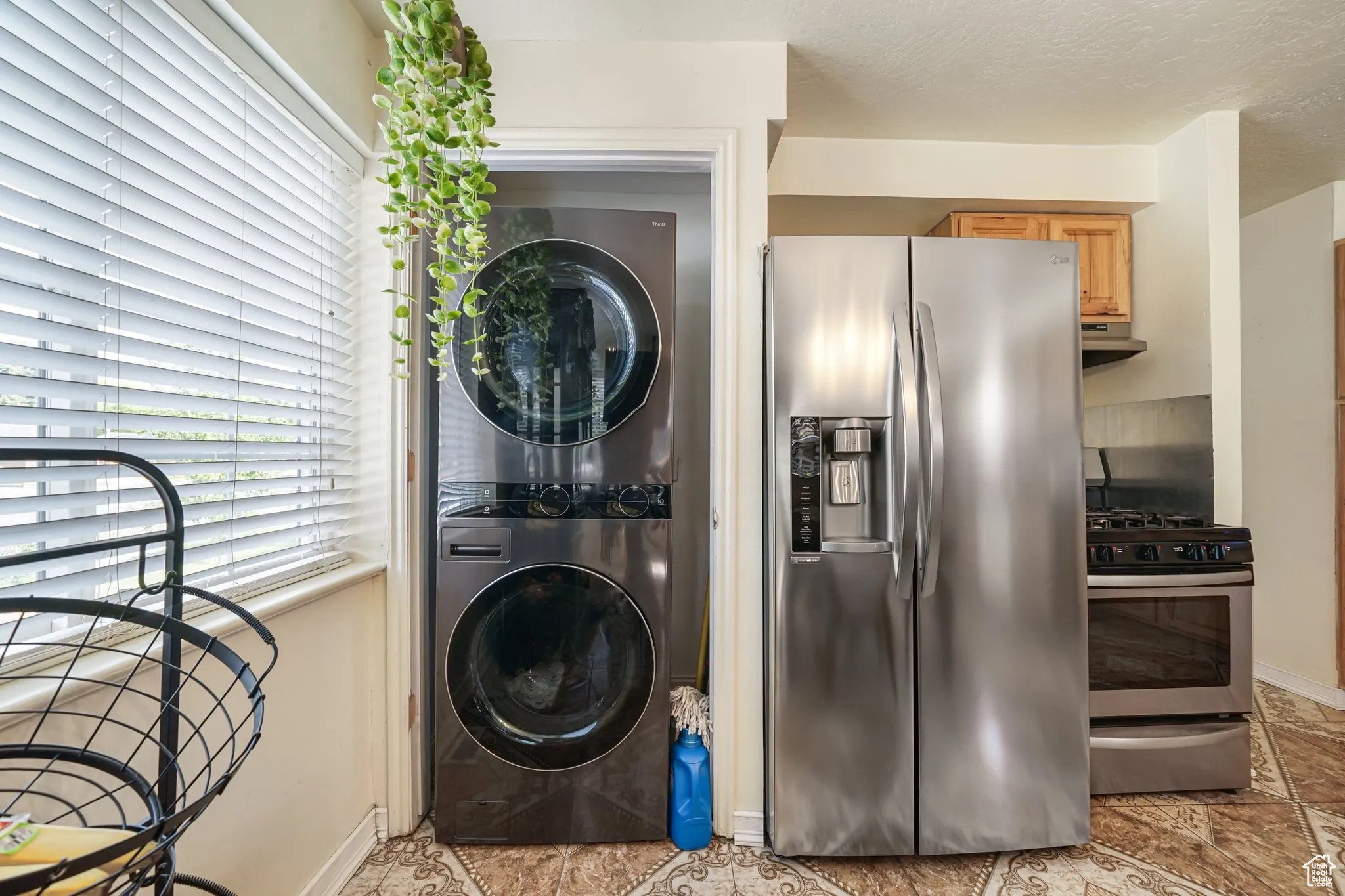 Washroom featuring stacked washing machine and dryer and baseboards