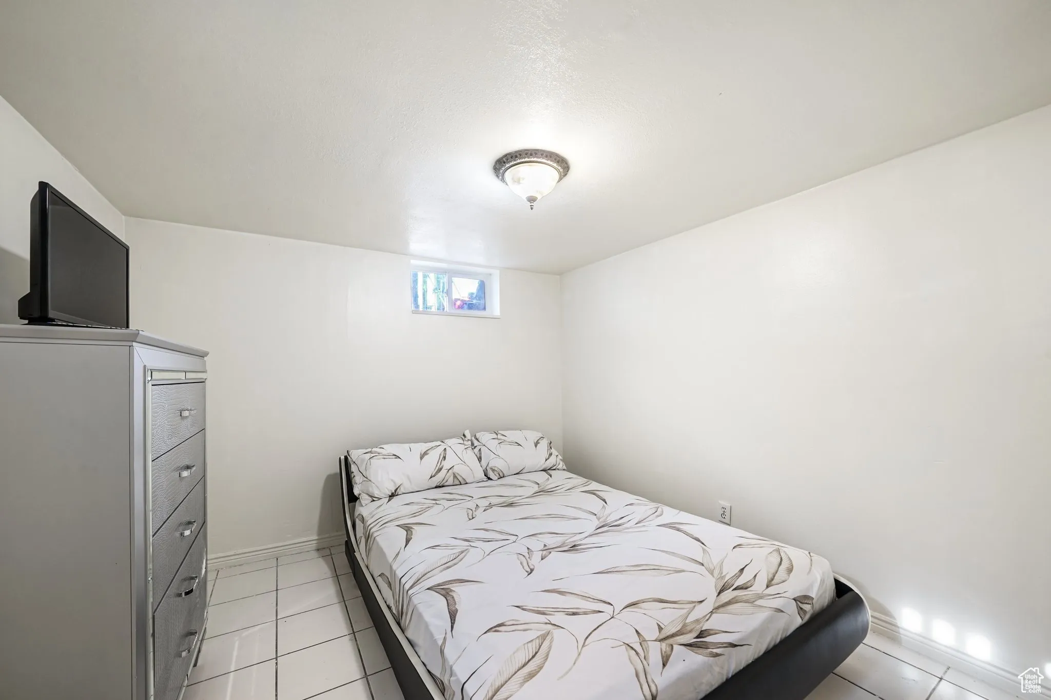 Bedroom featuring light tile patterned floors and baseboards