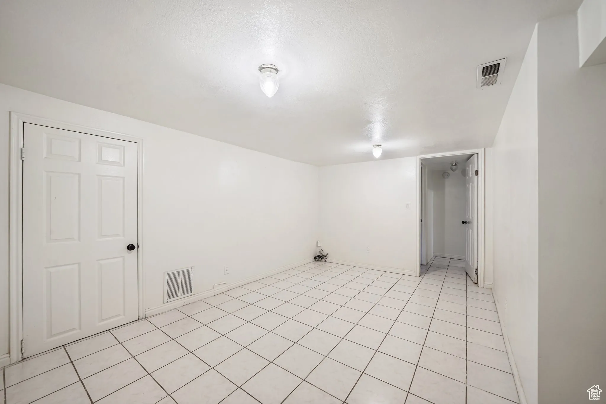 Spare room featuring light tile patterned floors and baseboards