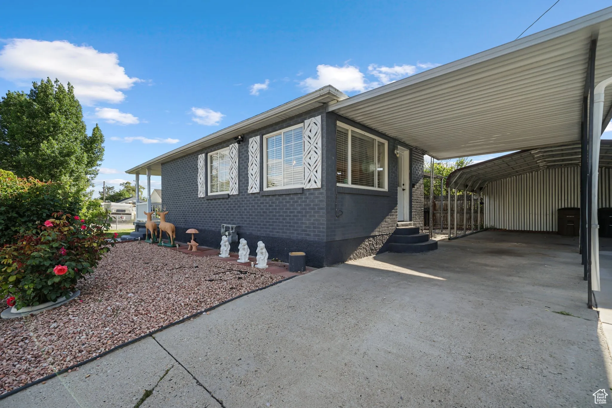 View of home's exterior with entry steps, concrete driveway, and brick siding