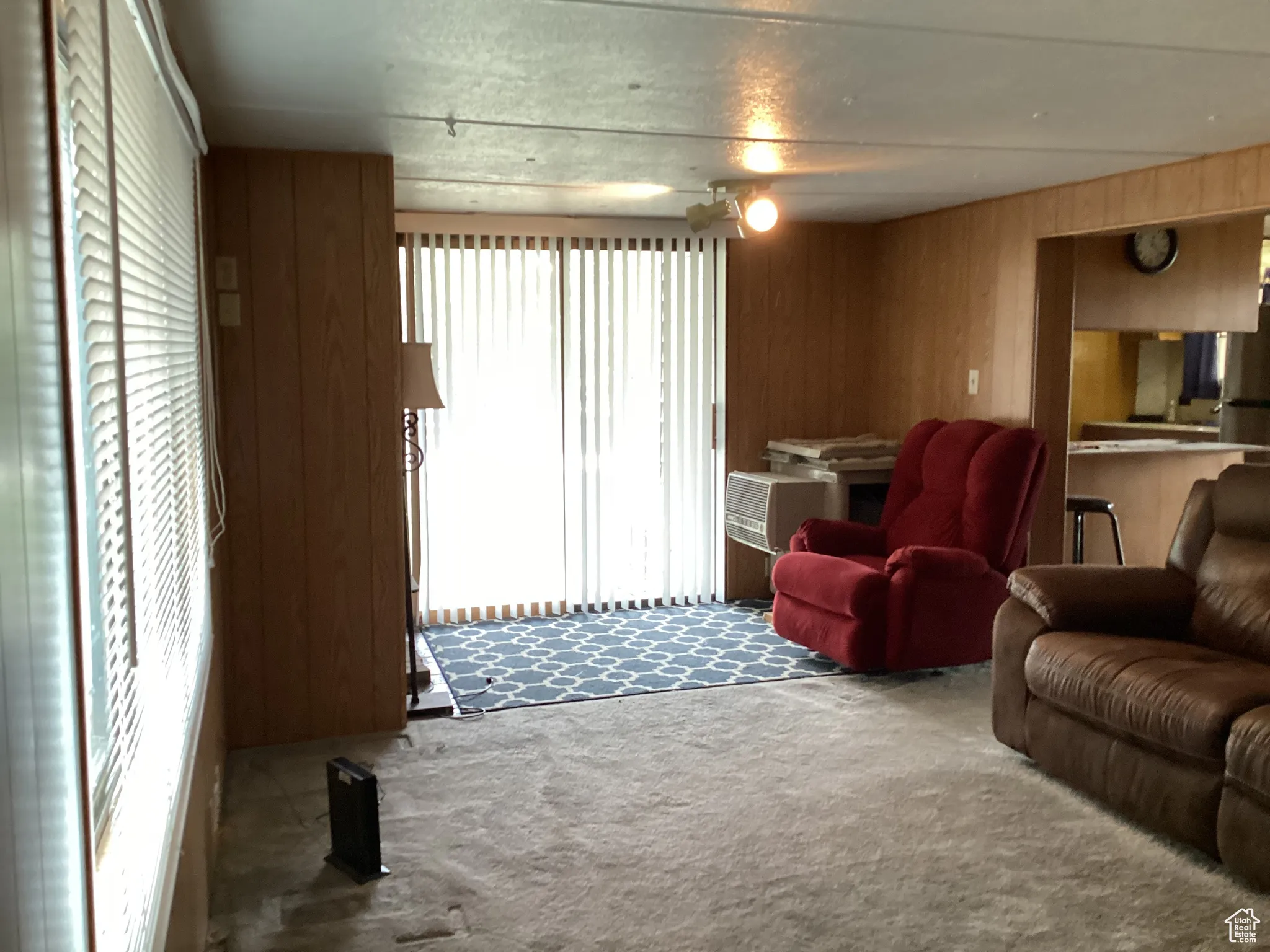Carpeted living area featuring healthy amount of natural light and wood walls