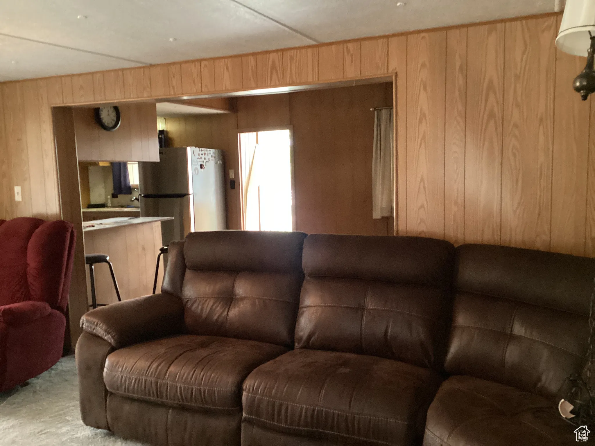 Living area featuring wooden walls and light carpet