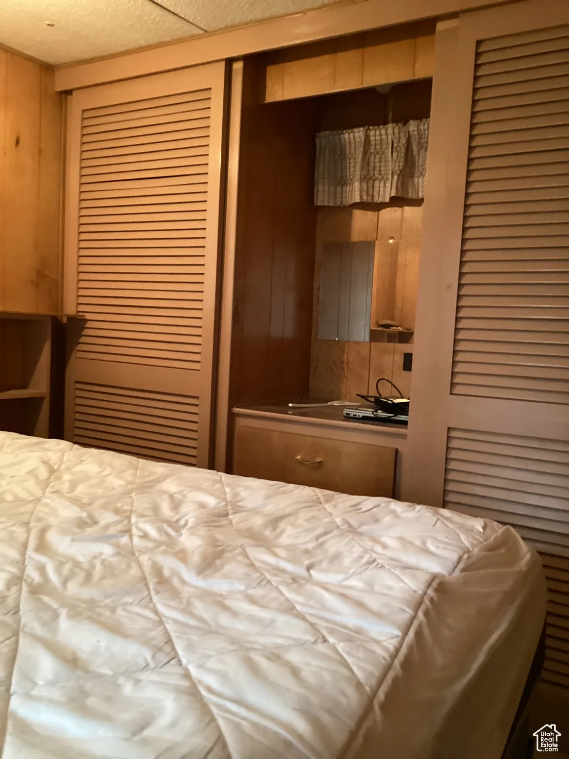 Bedroom with a closet and wooden walls