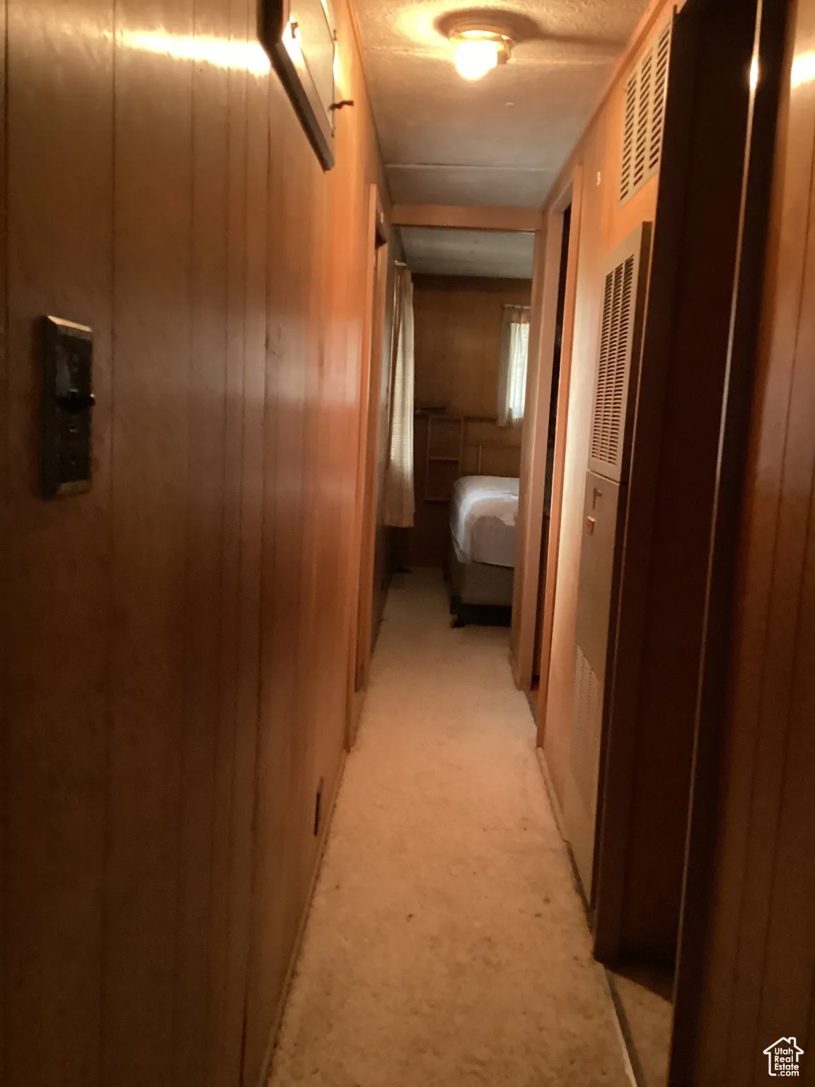 Hallway featuring light carpet