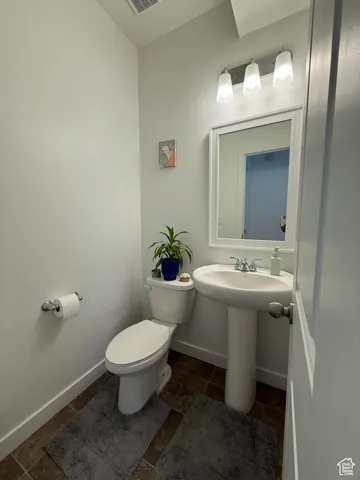 Half bath featuring toilet and baseboards