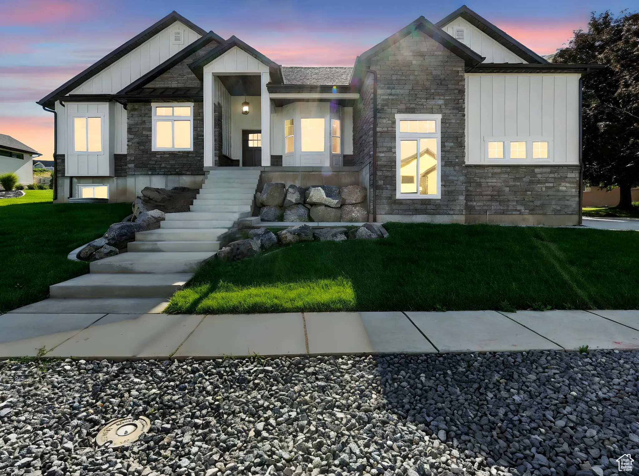Modern inspired farmhouse featuring board and batten siding, stone siding, and a yard