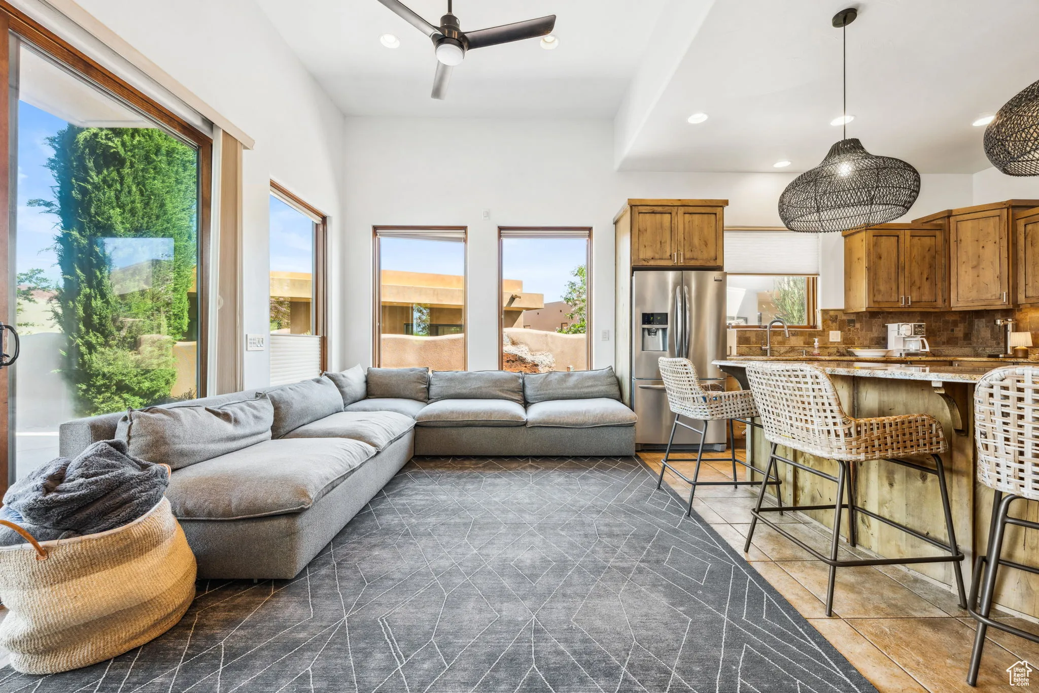 Living room with healthy amount of natural light, recessed lighting, dark tile patterned flooring, and a ceiling fan
