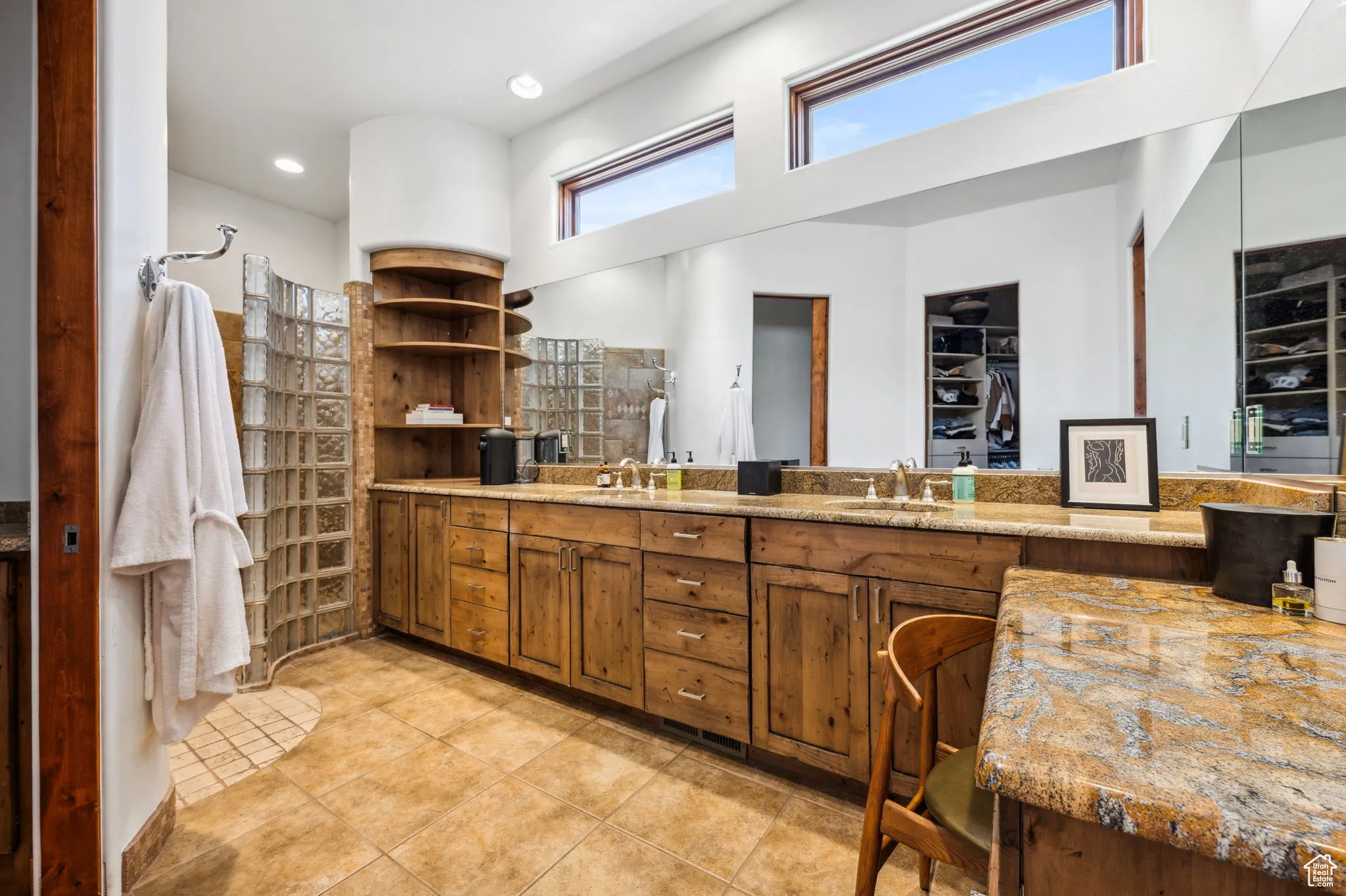 Bathroom with double vanity, walk in shower, a towering ceiling, tile patterned floors, and a spacious closet