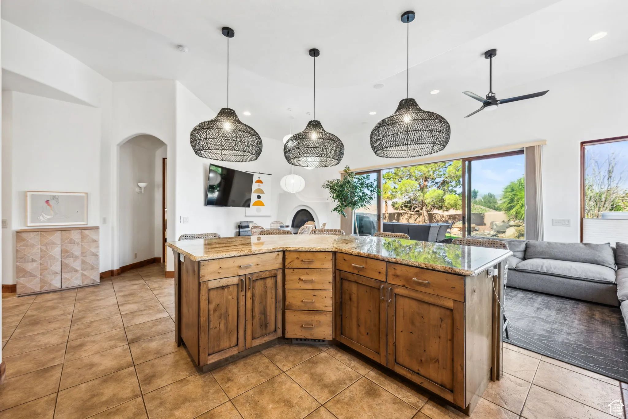 Kitchen featuring open floor plan, arched walkways, recessed lighting, light tile patterned floors, and ceiling fan
