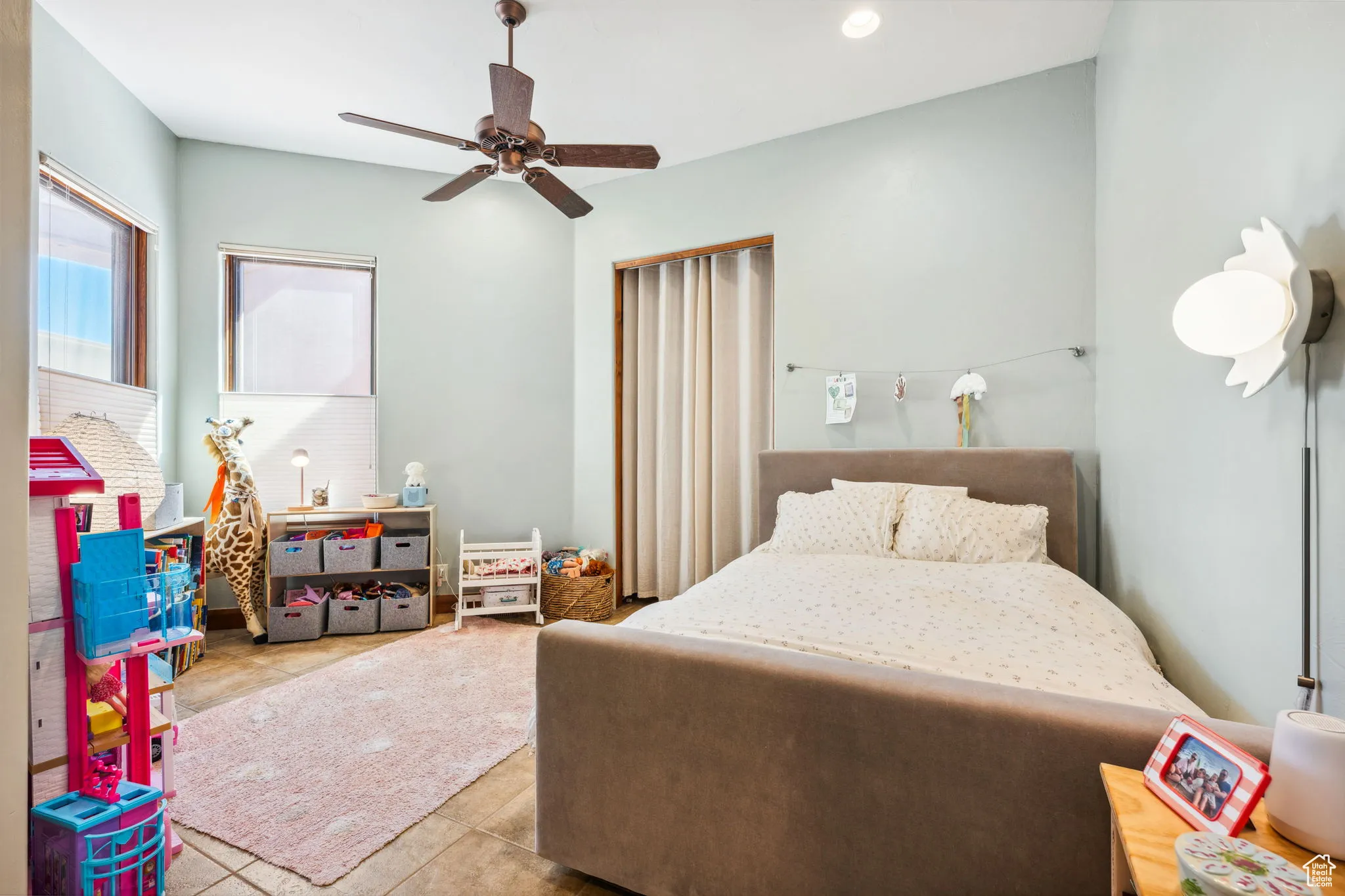 Tiled bedroom with a ceiling fan