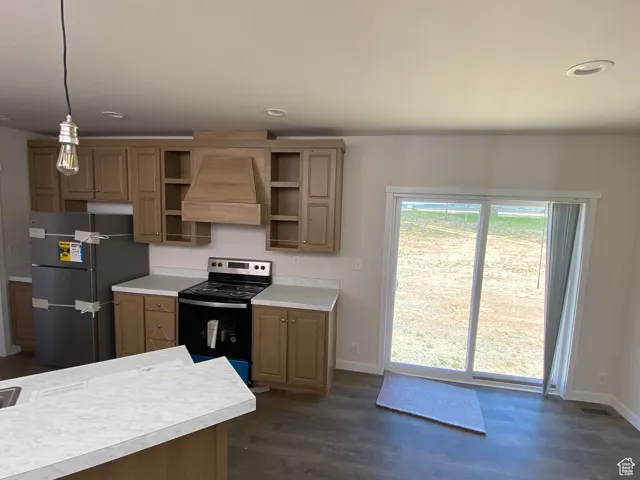 Kitchen with freestanding refrigerator, electric stove, premium range hood, open shelves, and light countertops